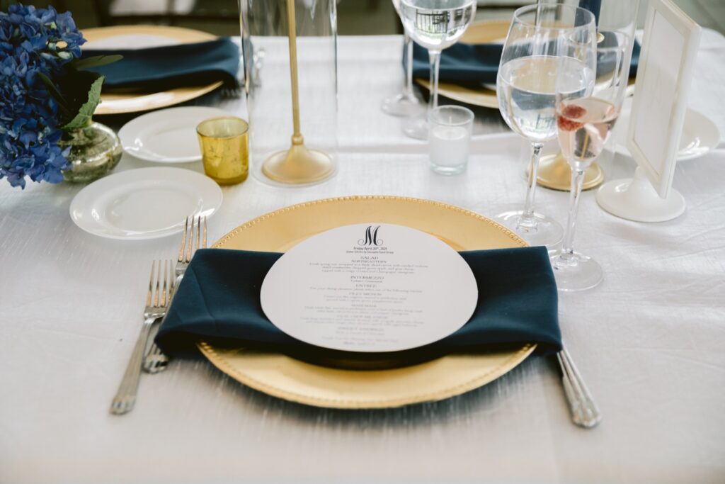 Wedding reception place setting with gold and blue accents