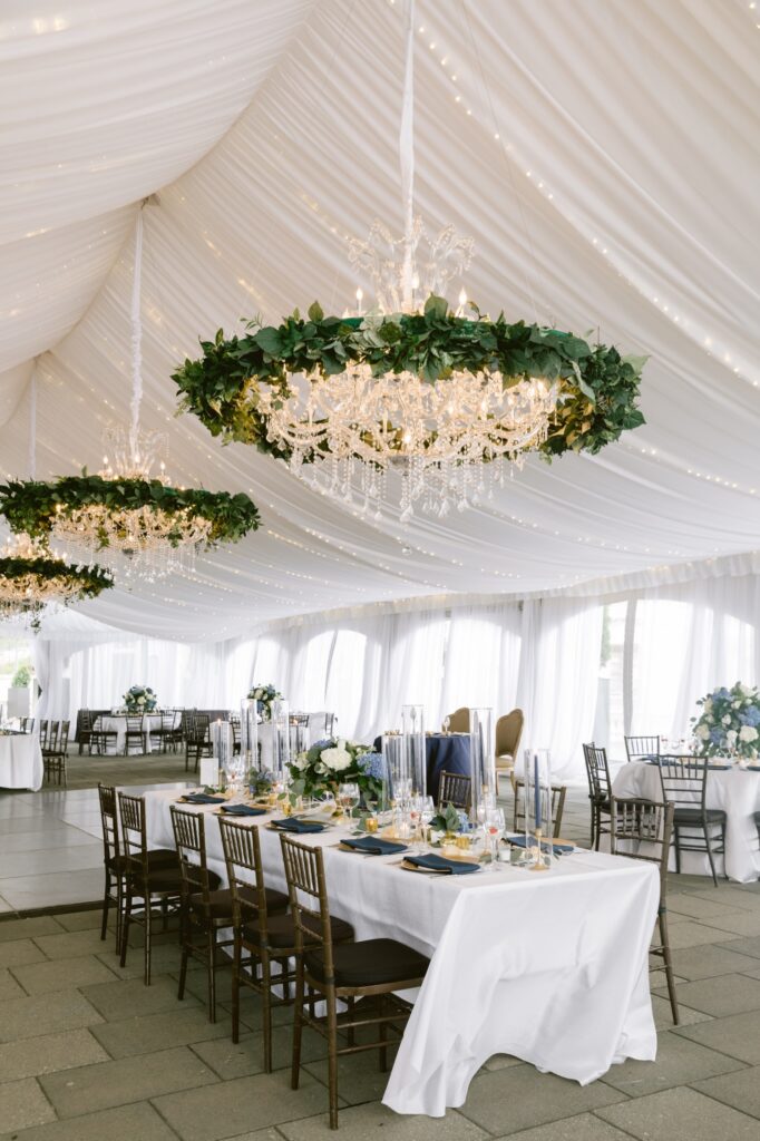 Tented spring wedding reception with twinkle lights and greenery
