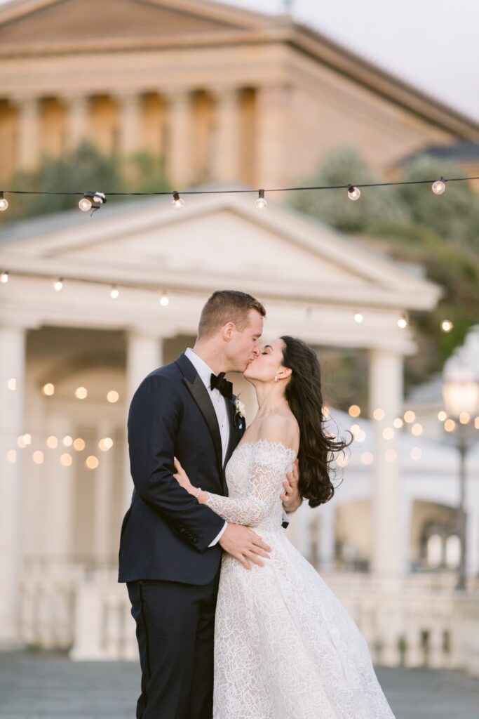 Newlyweds kissing at sunset at their elegant Water Works wedding reception
