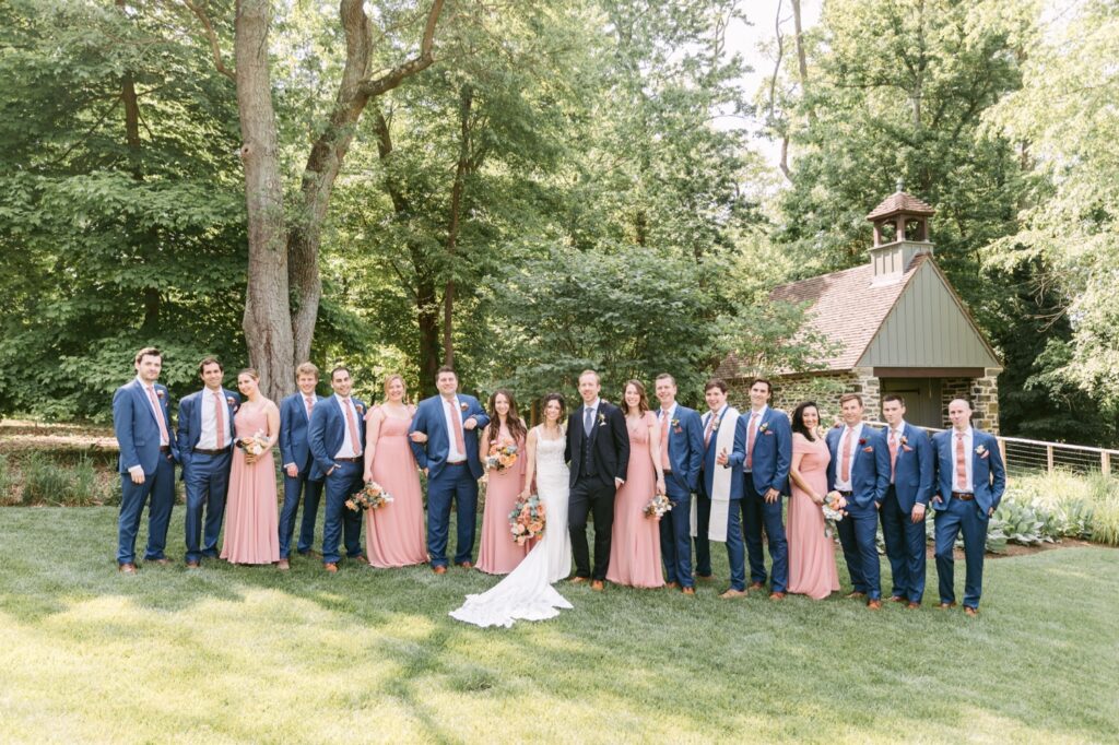 Bridesmaids and groomsmen smiling on a bright verdant wedding day in Pennsylvania
