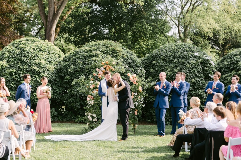 Bride and groom's first kiss during an enchanting spring wedding day on the Main Line