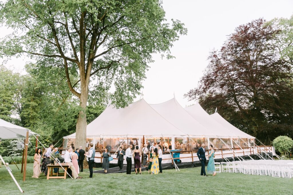 Guests enjoying a backyard wedding reception tent on a bright spring evening near Philadelphia