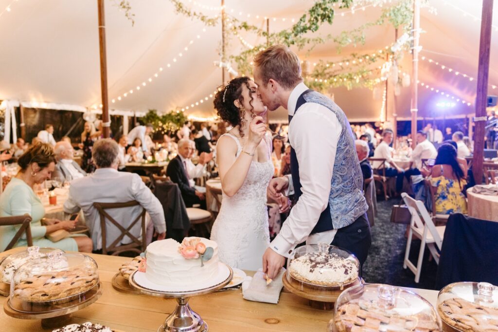 Bride and groom kissing after cake cutting at a enchanted spring wedding reception on the Main Line