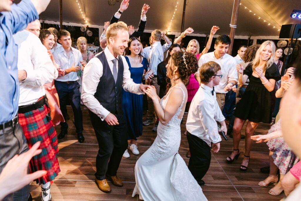 Bride and groom dancing with their guests at a luxury backyard wedding reception on the Main Line