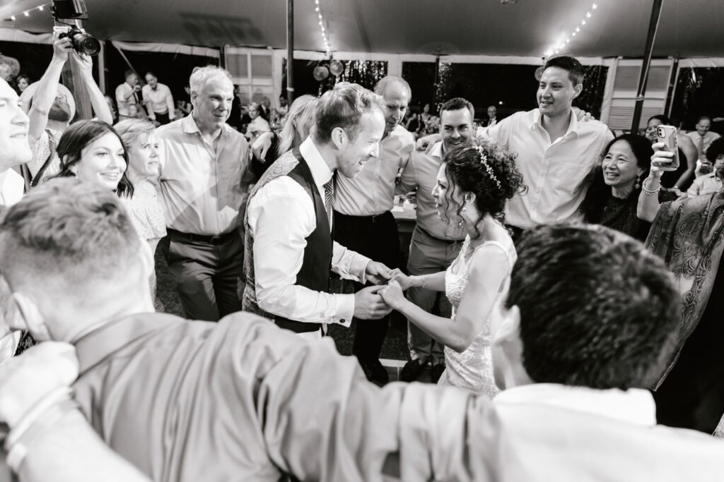 Newlywed couple celebrating with wedding guests on the dance floor of an enchanting backyard reception