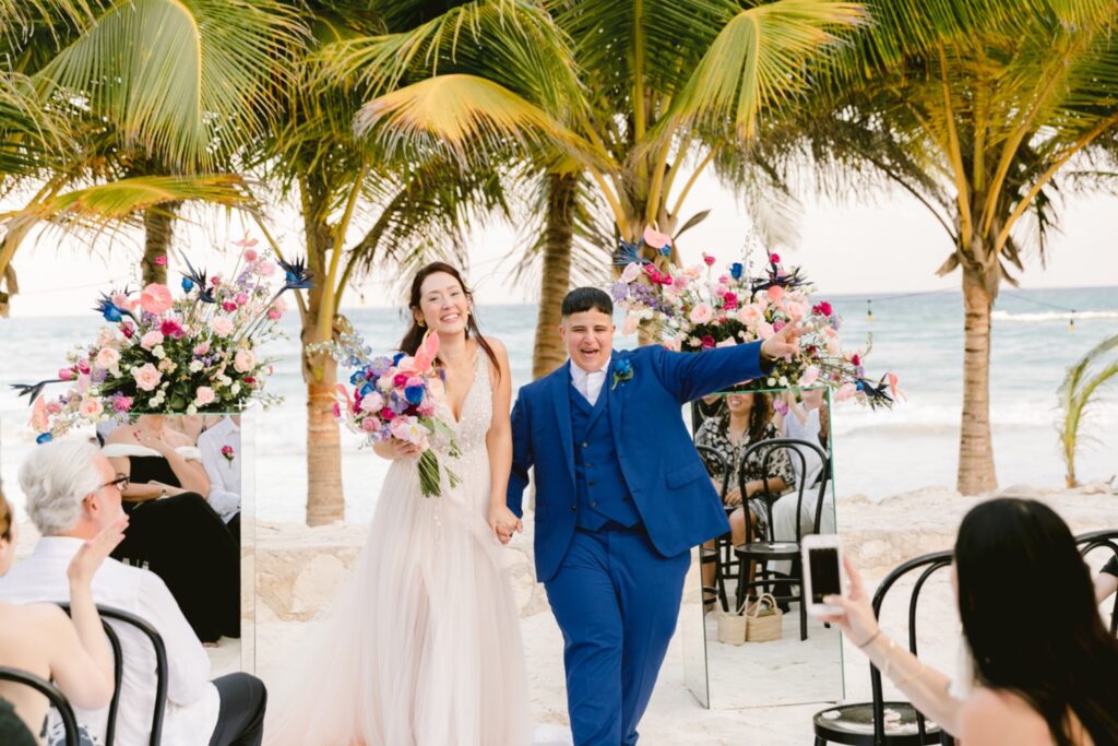 Lesbian couple celebrate after tying the knot at a tropical destination wedding ceremony
