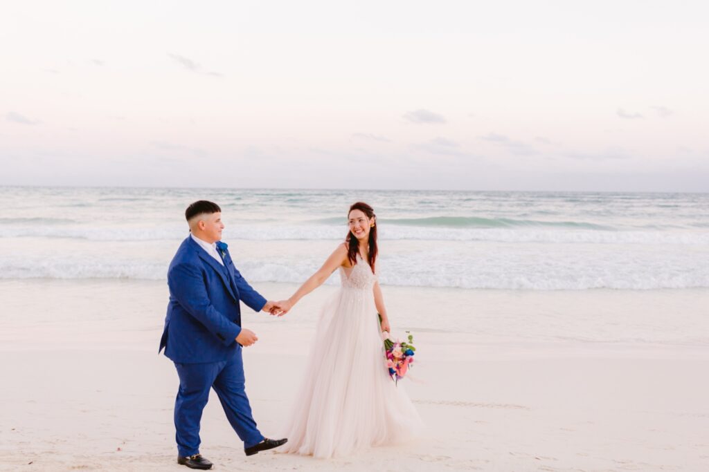 LGBTQ couple walking on the beach on their tropical wedding day