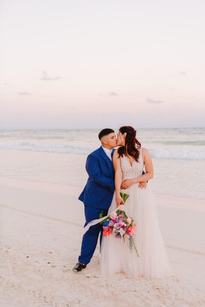 LGBTQ brides embracing at sunset at a tropical oasis destination wedding