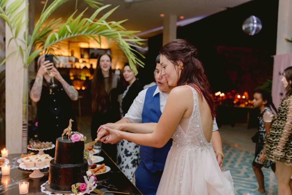 LGBTQ couple cuts their wedding cake at a luxury resort wedding in Tulum