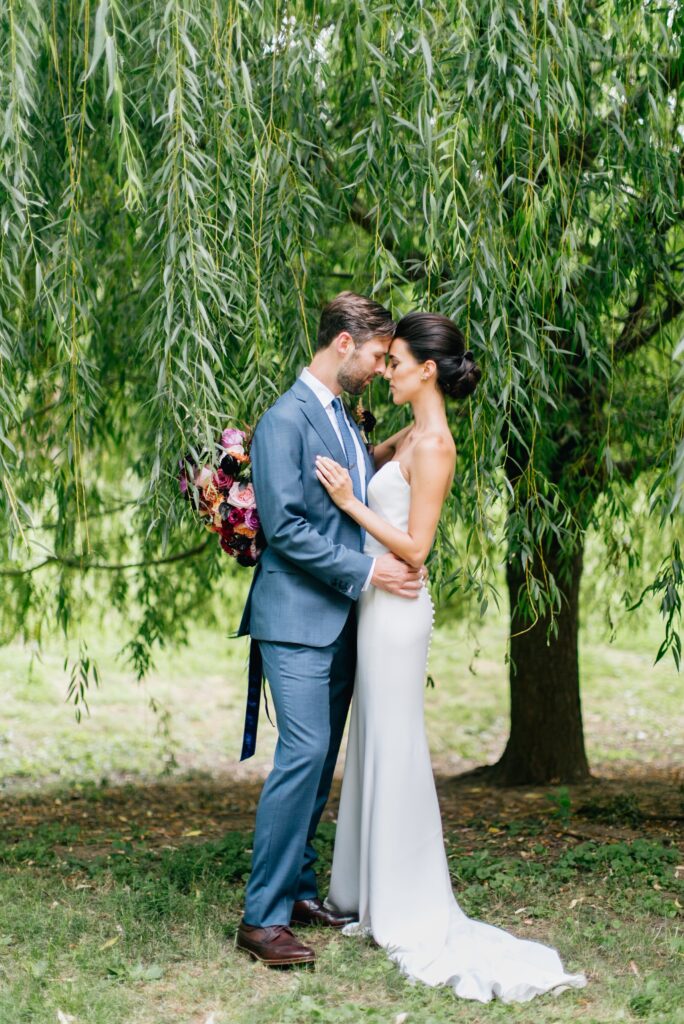 Bride and groom in front of a willow tree at the 18th Century Garden in Philadelphia