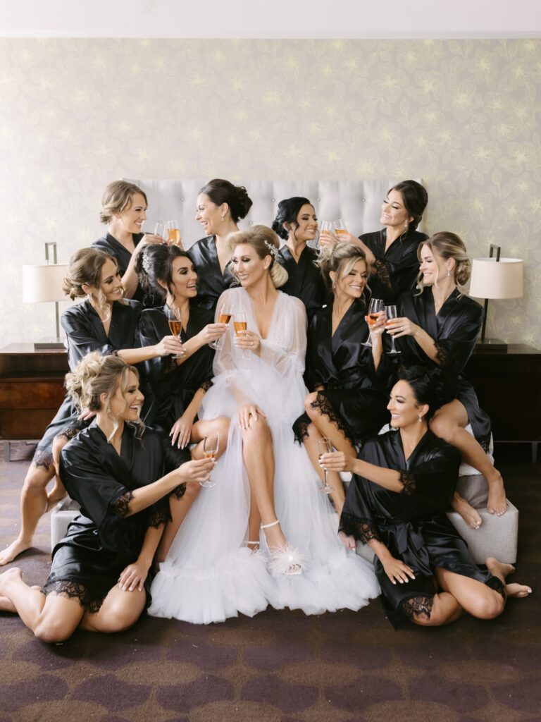 Bride and bridesmaids drinking champagne while getting ready for a luxe wedding in Philadelphia