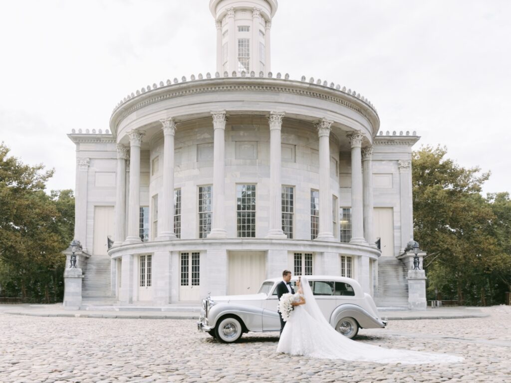 Bride and groom with a classic car outside the Merchant Exchange Building in Philadelphia