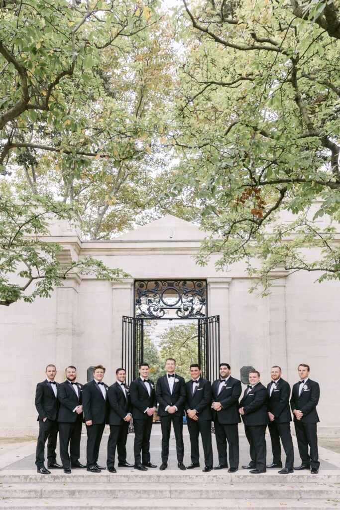 Groom and groomsmen in tuxes inside the Rodin Museum