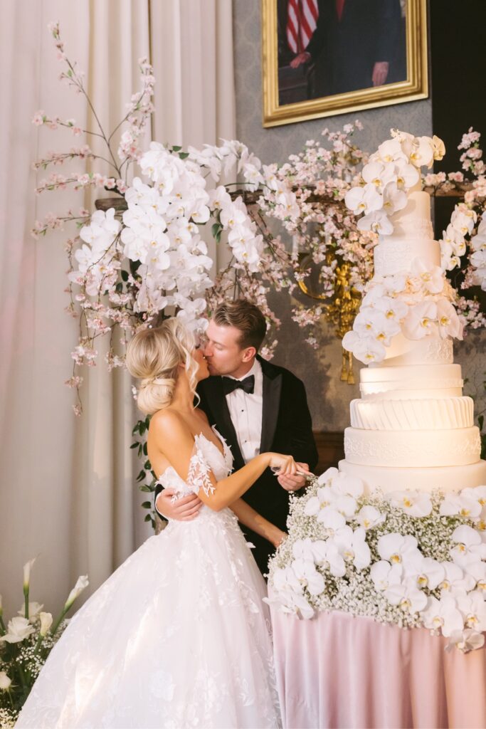 Bride and groom cutting their multi tiered wedding cake at an upscale Union League reception