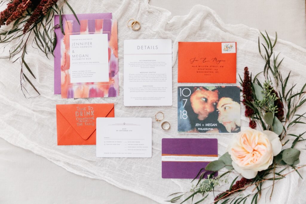 Purple and orange invitation suite for an interracial LGBTQ wedding celebration