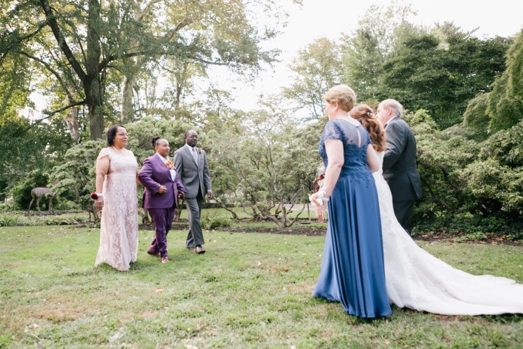 LGBTQ couple meeting in the center of the aisle during a playful wedding ceremony