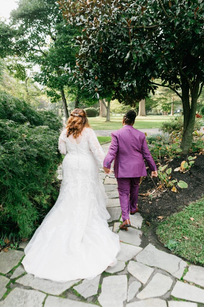 Couple holding hands and walking away after a LGBTQ wedding ceremony