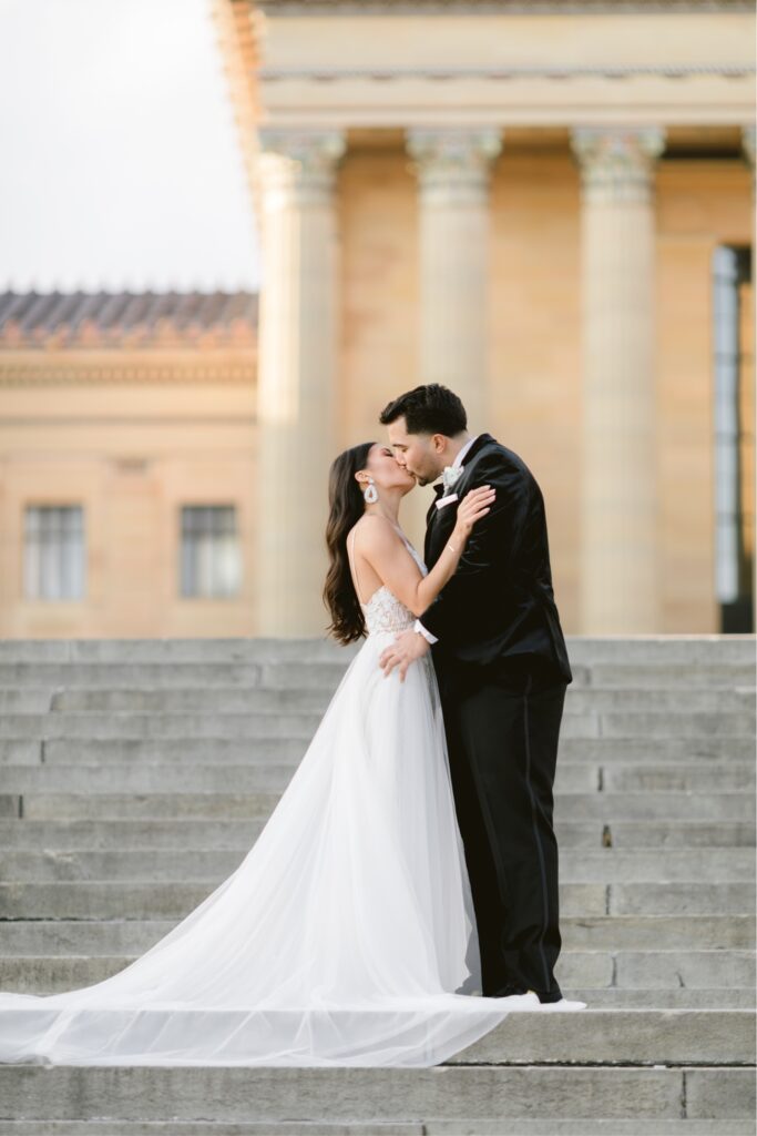 Bride and groom kissing on the steps of the Philadelphia Art Museum