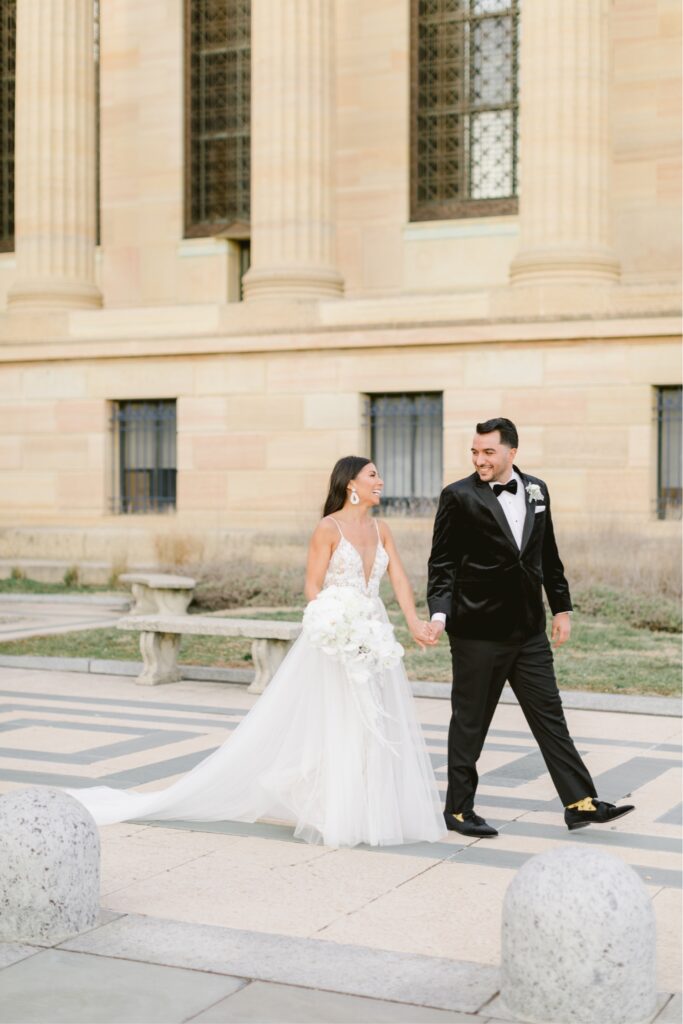 Bride and groom laughing and walking at the Art Museum in Philadelphia