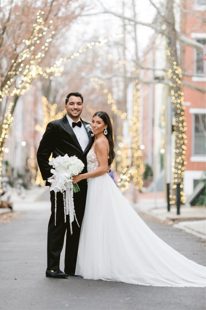 Bride and groom smiling on a twinkle light street in Philadelphia