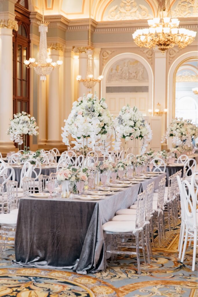 Tall white floral centerpieces on a rectangular table at a stylish Academy of Music wedding reception
