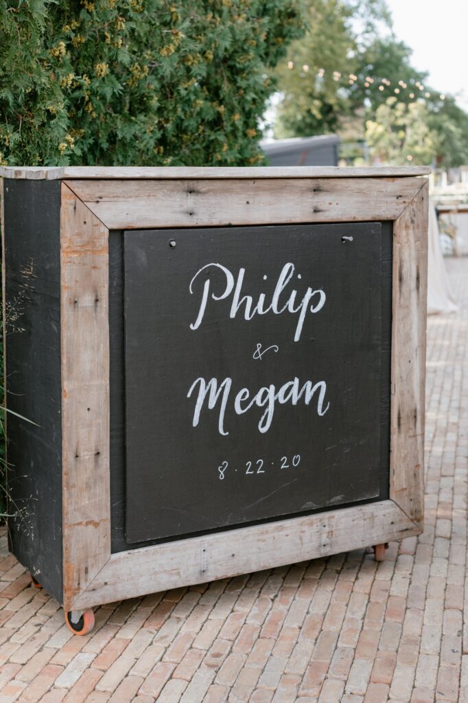 Chalkboard sign with the bride and groom's names outside of an intimate wedding ceremony