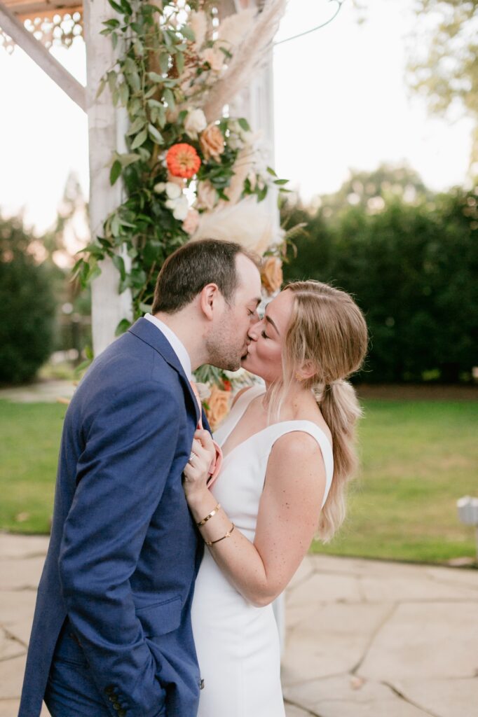 Newlyweds kissing during golden hour on an intimate summer wedding day