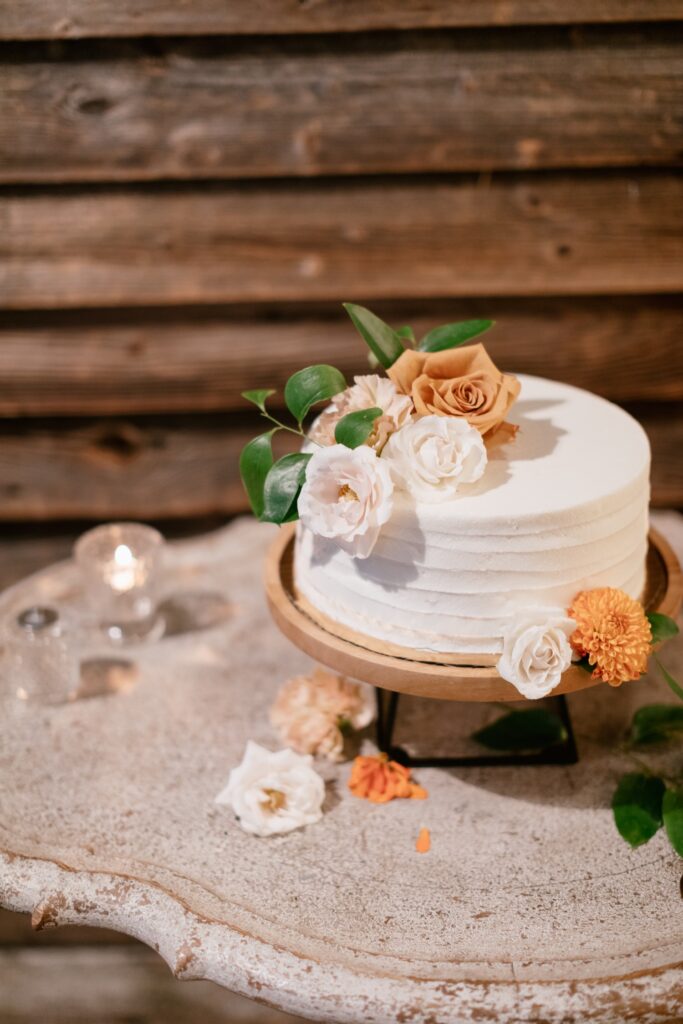 Orange flowers on top of a small wedding cake at a micro wedding celebration near Philadelphia