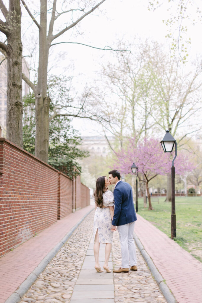 Couple kissing with cherry blossoms in the background