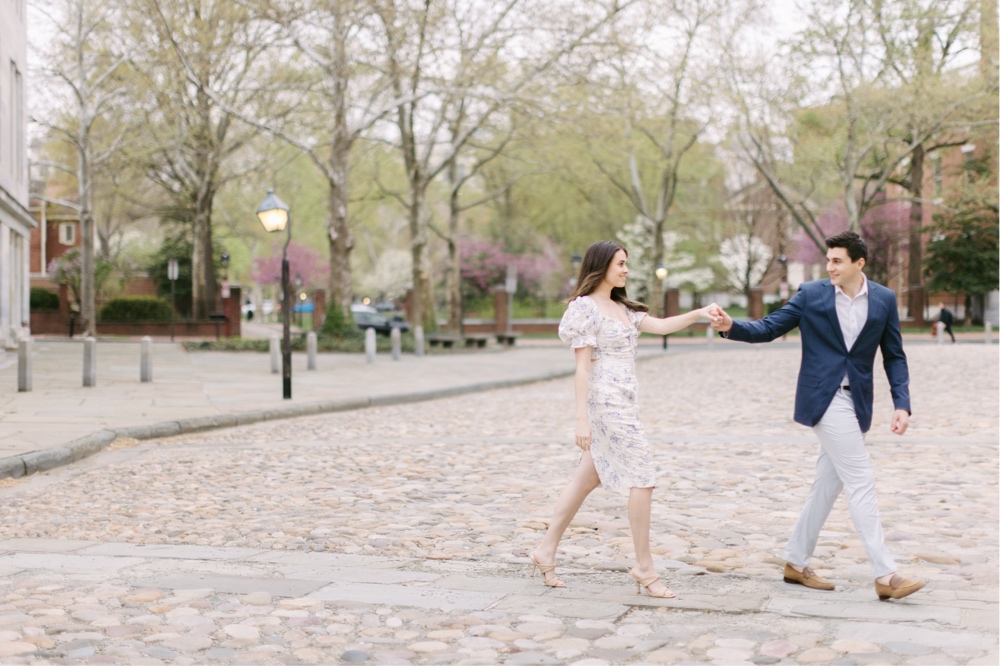 Couple walking along cobblestone streets during an Old City engagement session