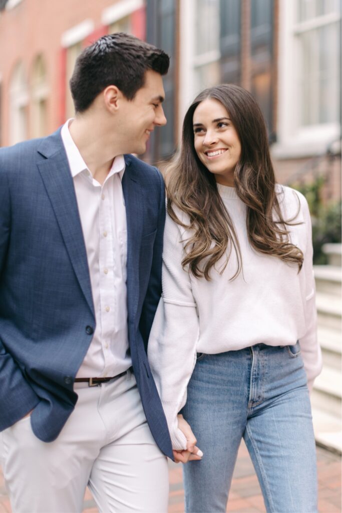 Engaged couple walking through Old City in Philadelphia by Emily Wren Photography