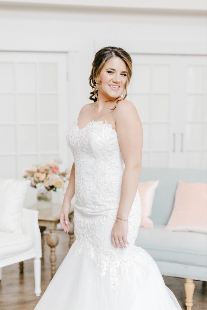 Bride in a mermaid wedding dress with lace details on the morning of a spring wedding