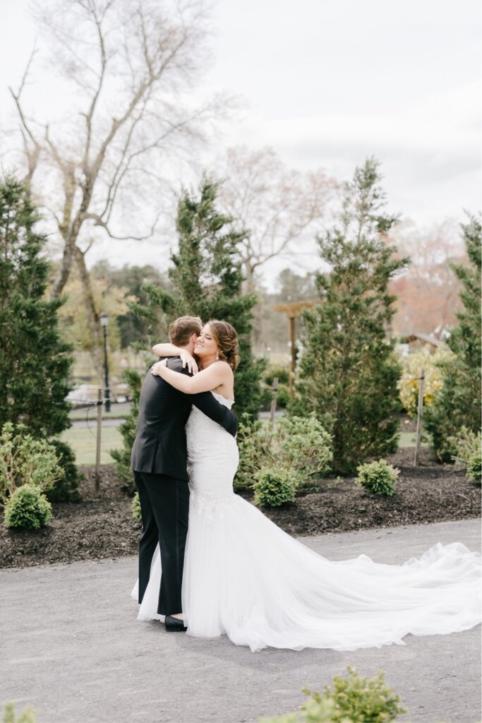 Bride and groom hug during their first look at an enchanting winery in Cape May, New Jersey