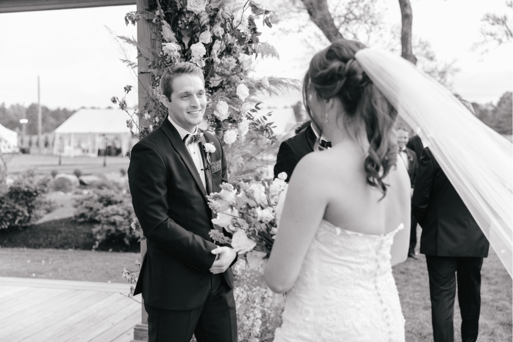 Groom sees the bride at an elegant outdoor ceremony for a spring winery wedding