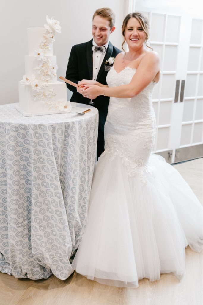 Bride and groom cut the wedding cake at an enchanting spring wedding reception