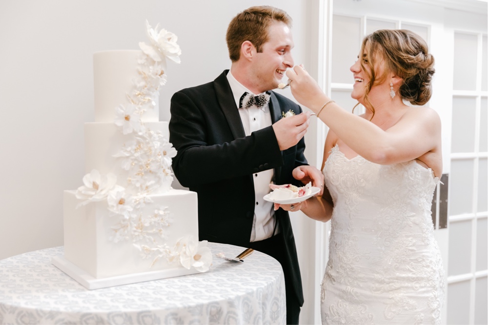 Bride and groom feed each other cake during a whimsical spring wedding reception at a NJ winery