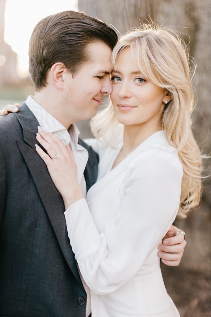 Engaged couple snuggling during a spring engagement session at golden hour