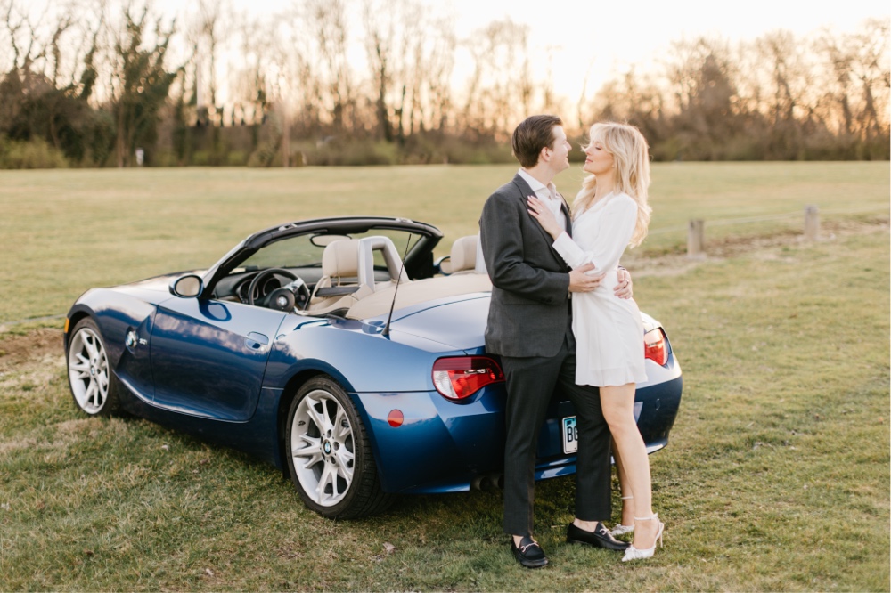 Engaged couple standing by a convertible during a vintage inspired engagement shoot near Philadelphia