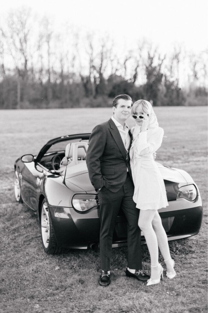 Couple leaning against a timeless convertible car during a spring vintage inspired engagement shoot near Philadelphia