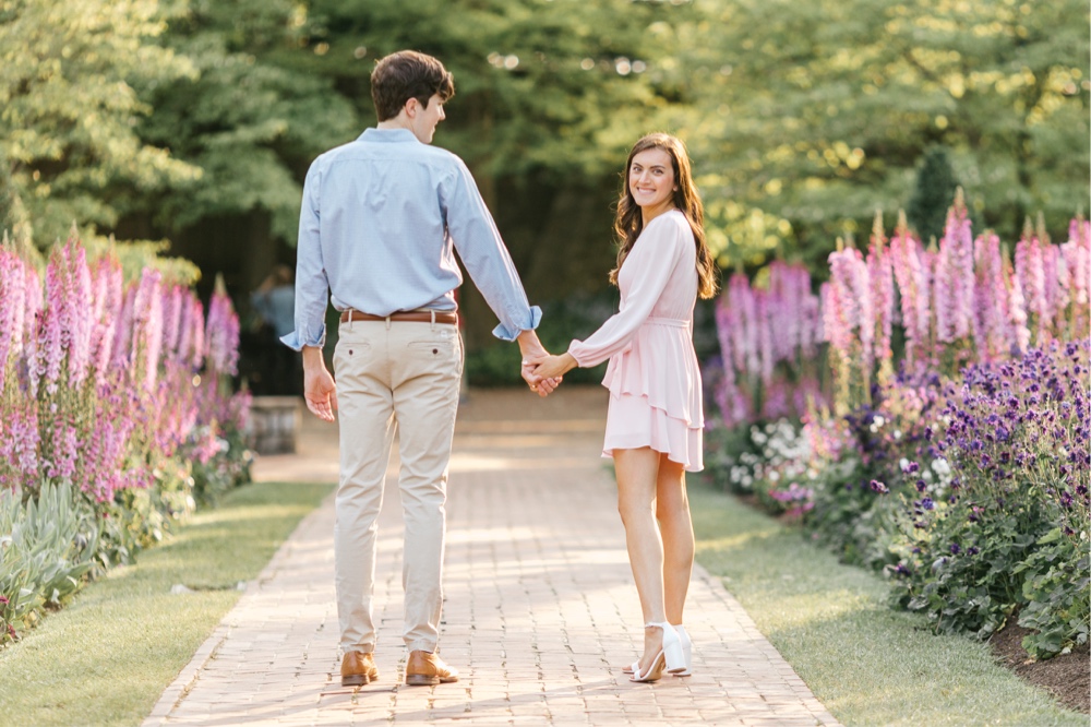 Couple strolling on a garden path with flowers during a Pennsylvania engagement session
