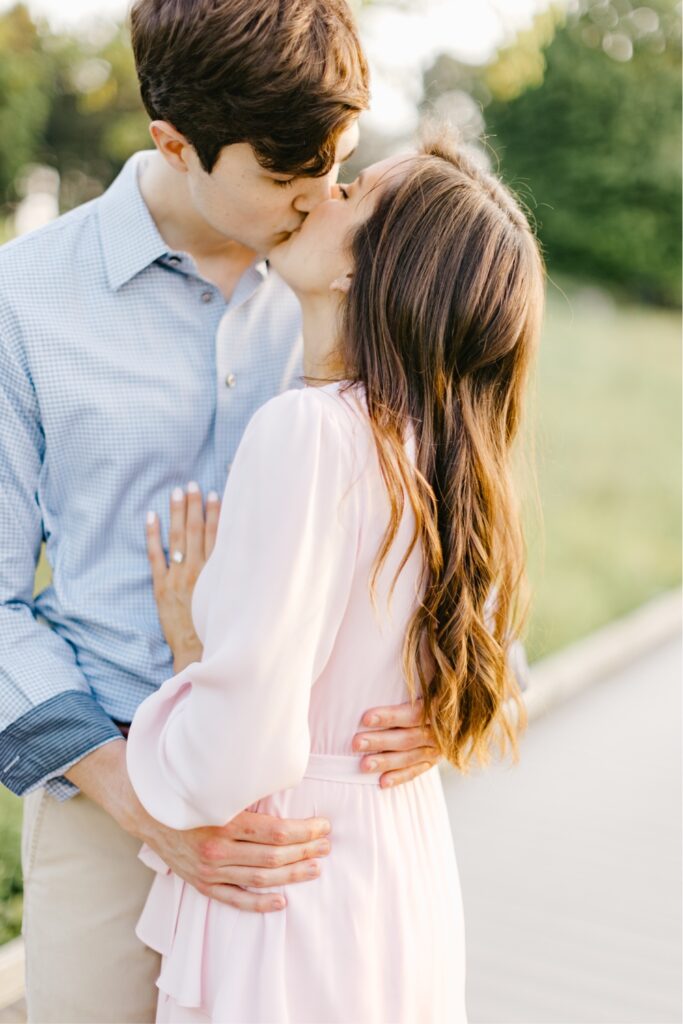 Couple kissing during golden hour at their spring engagement portrait session by Emily Wren Photography
