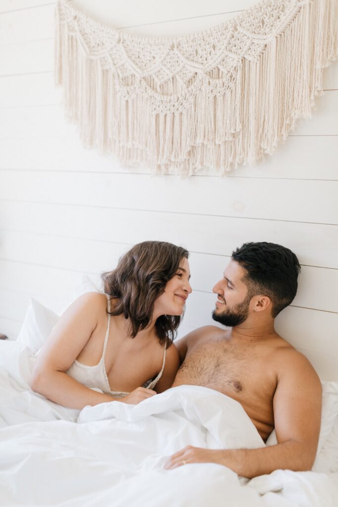 Couple lounging in bed the morning of their intimate destination wedding by Emily Wren Photography