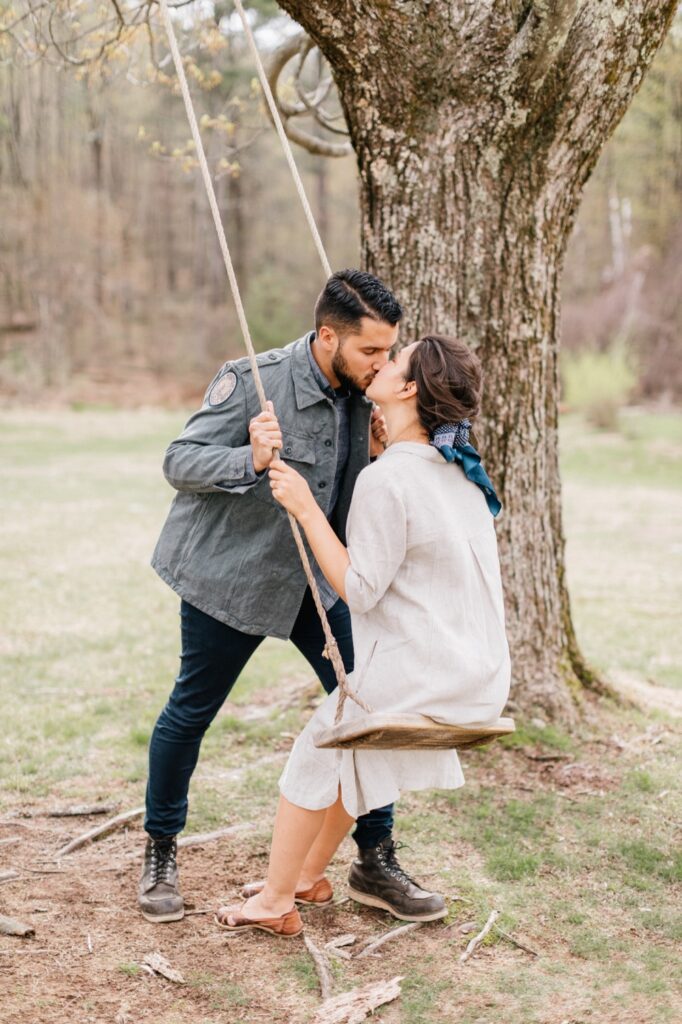 Bride and groom kissing on a swing the morning of their intimate destination wedding