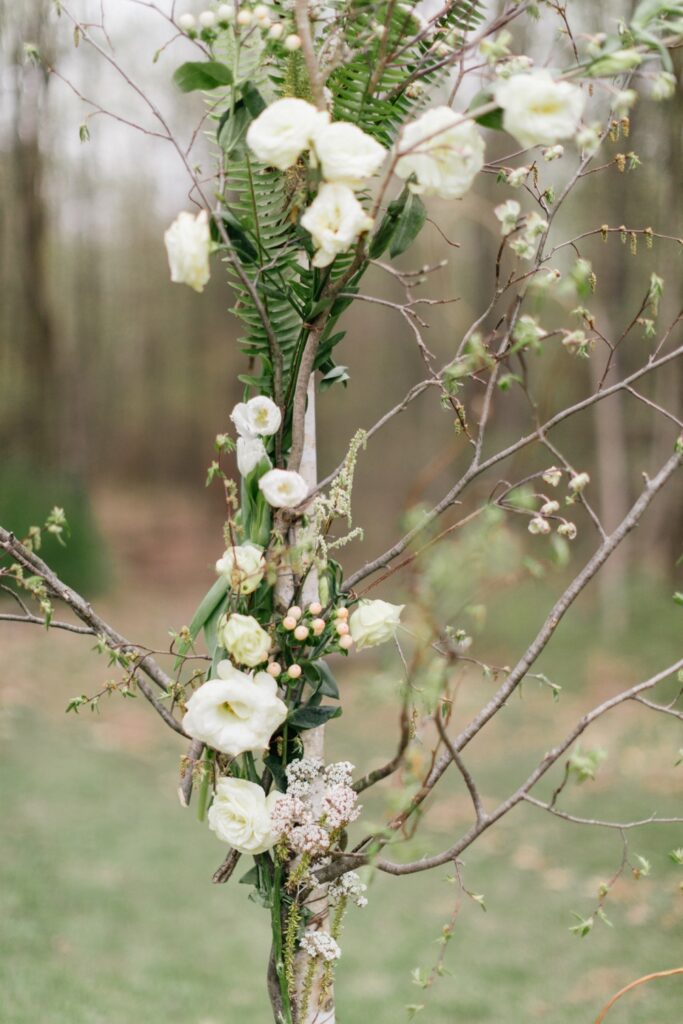 Rustic flowers and greenery on a woodland ceremony arch at a boutique hotel in upstate New York