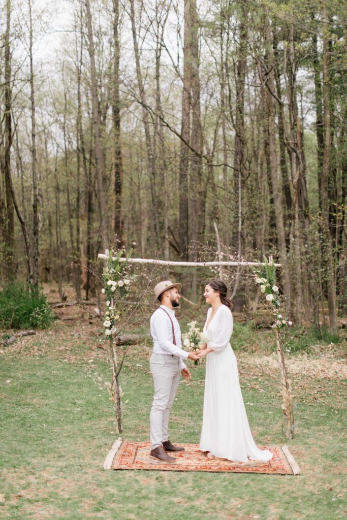 Couple at a rustic ceremony site in a field in upstate New York by Emily Wren Photography