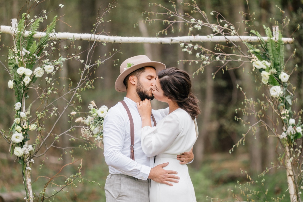 Bride and groom first kiss at an intimate outdoor wedding ceremony in upstate New York