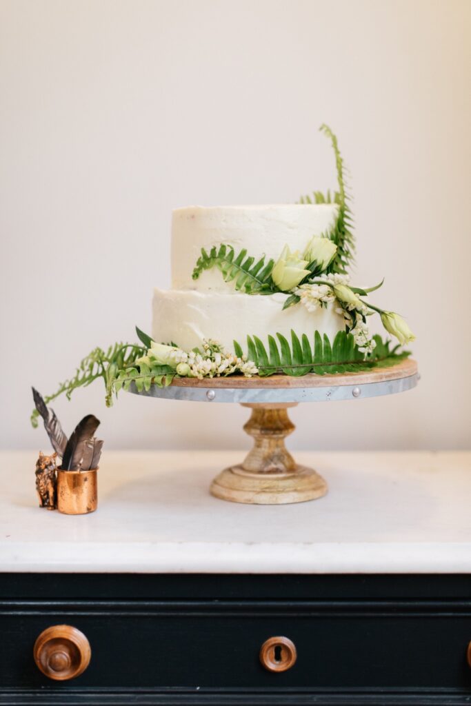 Wedding cake decorated with ferns at a rustic destination wedding by Emily Wren Photography