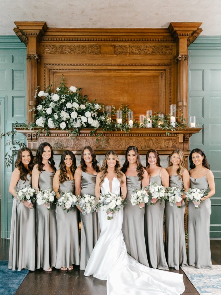 Bride and bridesmaids in front of the elegant fireplace at Natirar in New Jersey