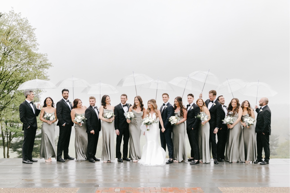Wedding party with clear umbrellas on a rainy spring wedding day by Emily Wren Photography
