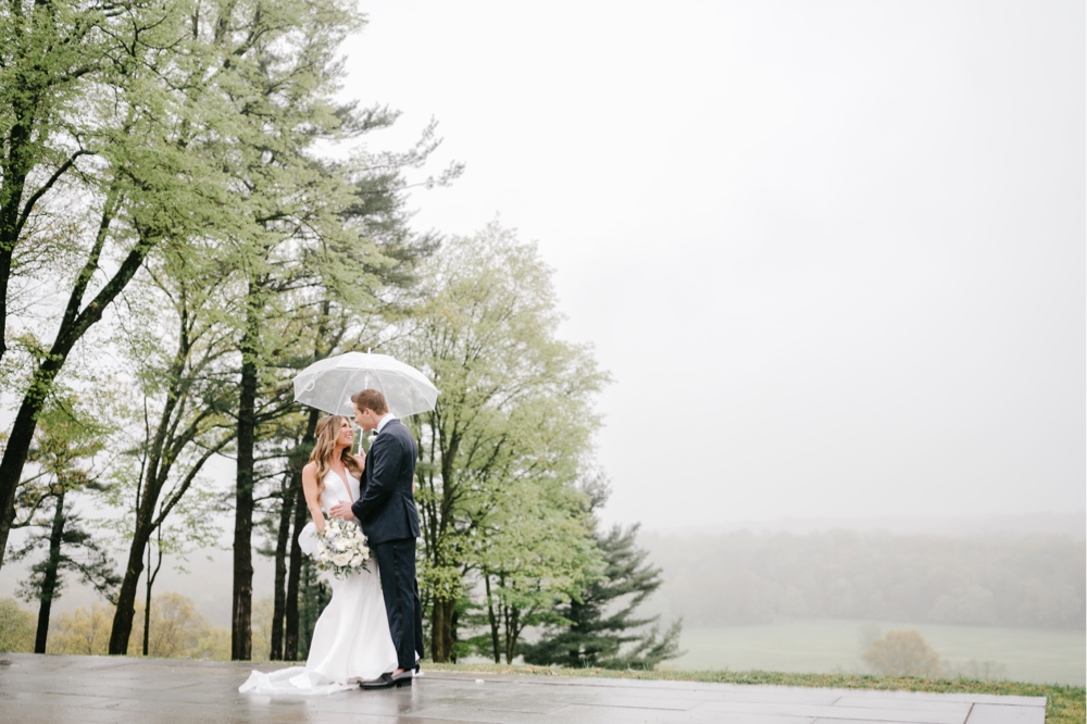 Bride and groom with a misty landscape on a rainy spring wedding day in New Jersey